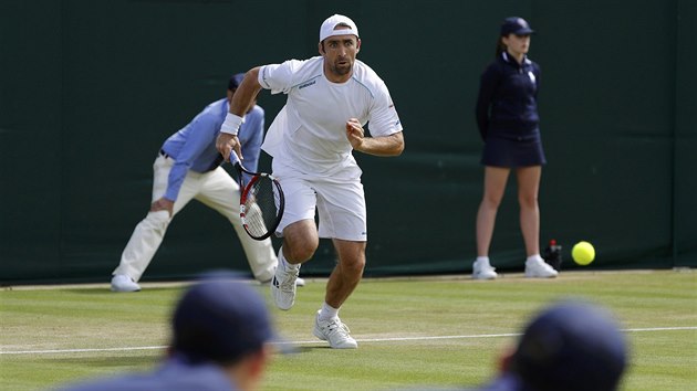 Nmeck tenista Benjamin Becker se sna dobhnout balonek, kter mu ve 2. kole Wimbledonu poslal Tom Berdych.