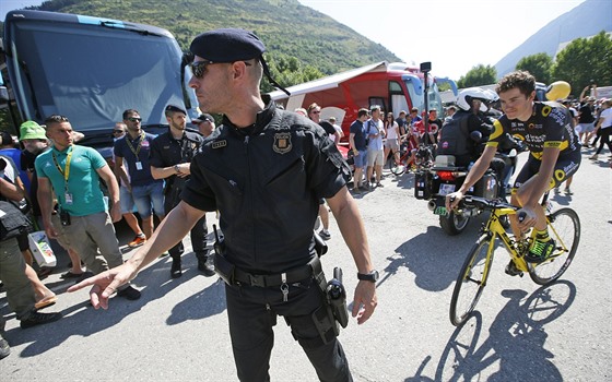 Policista dohlíí na diváky pi Tour de France. Projídí kolem nj Romain...