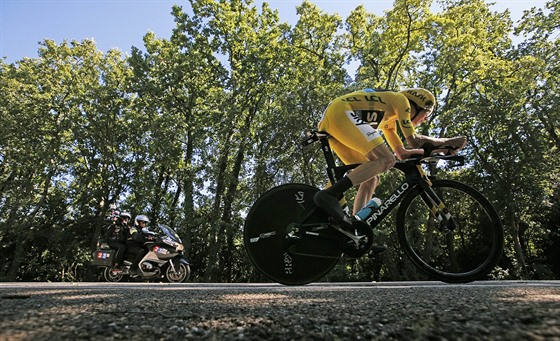 Chris Froome ve lutém trikotu vedoucího jezdce Tour de France uhání po trati...