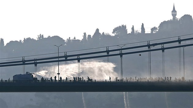 Policejn obrnn vz uil vodn dlo proti stoupencm pokusu o pevrat na most pes Bospor v Istanbulu.

A police armored vehicle uses a water cannon to disperse anti-government forces on Bosphorus Bridge in Istanbul