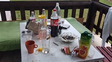 Na terase byl popelník plný nedopalků a pod stolem byly lahve s tvrdým... Na terase byl popelník plný nedopalků a pod stolem byly lahve s tvrdým...