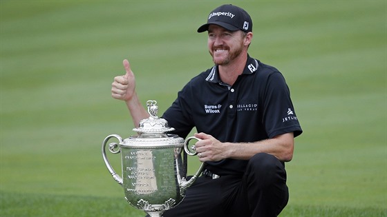 Americký golfista Jimmy Walker pózuje s trofejí pro vítze turnaje v...