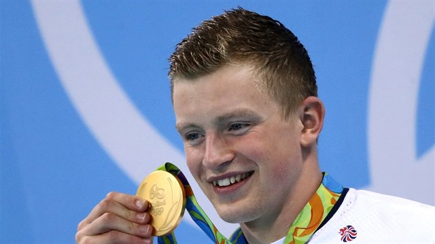 Britsk plavec Adam Peaty hrd ukazuje olympijsk zlato z trati sto metr prsa.