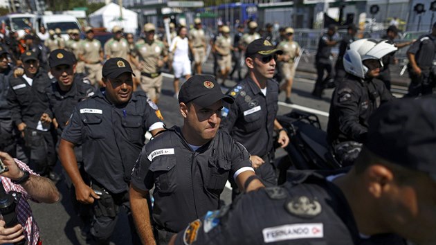 Kordon zamstnanc bezpenostn agentury obklopuje olympijskou pochode u ple Copacabana v Riu de Janeiro (5. srpna 2016)