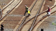 Lidé procházejí kolejištěm na sokolovském nádraží. Za hodinu jich bývá i pět... Lidé procházejí kolejištěm na sokolovském nádraží. Za hodinu jich bývá i pět...