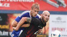 Olomoucký fotbalista Uro Radakovi (vlevo) svádí souboj s opavským Tomáem...