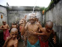 SVATÁ KOUPEL. Nepáltí chlapci si dopávají svatou koupel bhem rituálu Janai...