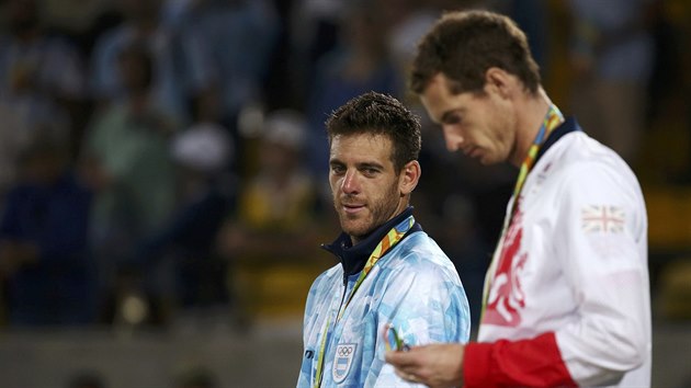 TU JSEM CHTL. Juan Martn Del Potro pozoruje zlatou medaili v ruce Andyho Murrayho.