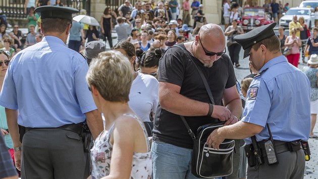 Reportr MF DNES Vclav Janou prochz kontrolou pi vstupu do Hradu. Za pasem m plynovou pistoli. Reporti pes kontroly dostali i n s dvaceticentimetrovou epel a jet dal loveck n. (15. srpna 2016)