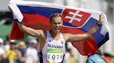 Slovenský chodec Matej Tóth s vlajkou slaví olympijský triumf v závod na 50...