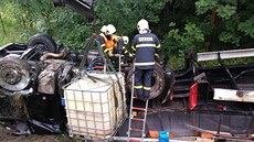 Hasiči přečerpávající naftu z havarovaného polského kamionu. Hasiči přečerpávající naftu z havarovaného polského kamionu.
