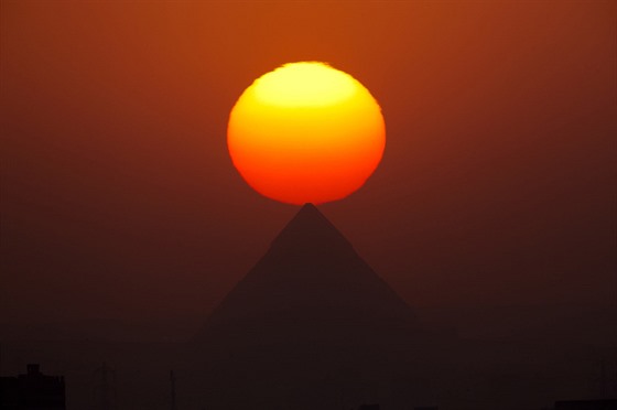NEKROPOLIS. Slunce zapad za pyramidami v Gze. Na nhorn ploin nad...