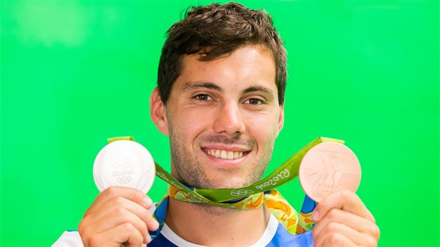 Kajak Josef Dostl ukazuje ve studiu iDNES.cz sv dv olympijsk medaile z her v Rio de Janeiru.