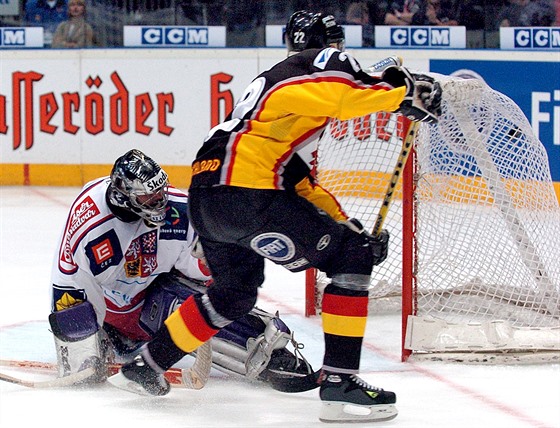 VZPOMÍNKA NA ROK 2004. Nmecký hokejista Tino Boss stílí branku eskému gólmanovi Romanu echmánkovi bhem utkání základní ásti Svtového poháru v záí 2004.