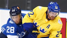 Švédský útočník Daniel Sedin (vpravo) si kryje puk před Laurim Korpikoskim z... Švédský útočník Daniel Sedin (vpravo) si kryje puk před Laurim Korpikoskim z...