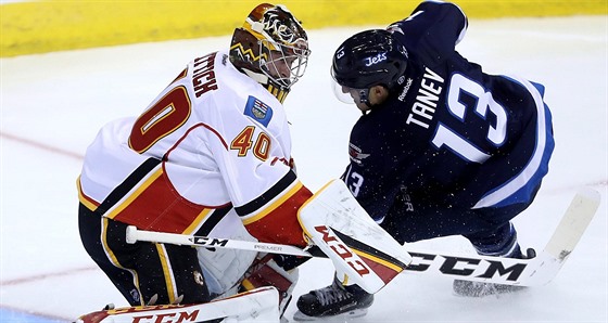 Calgarský gólman  David Rittich likviduje anci Brandona Taneva z Winnipegu.