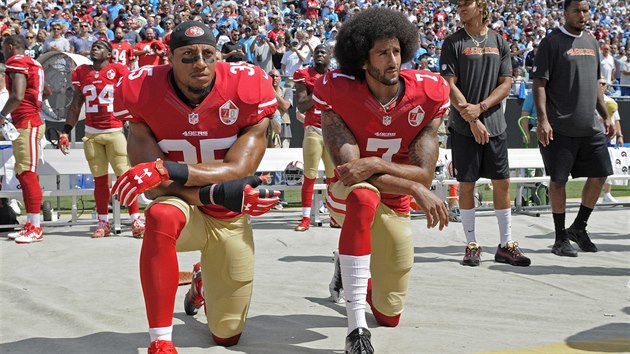 Hri San Francisco 49ers Colin Kaepernick (vlevo) a Eric Reid kle bhem hymny ped zpasem NFL proti Carolina Panthers.