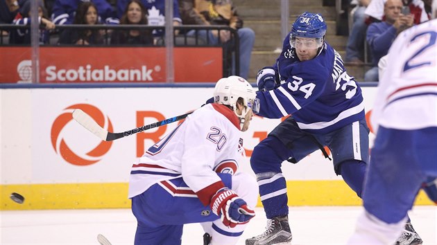 Auston Matthews (v modrm) stl v ppravnm utkn  hokejov NHL mezi Montreal Canadiens a Toronto Maple Leafs.