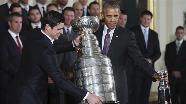 Americk prezident Barack Obama a kapitn Pittsburghu Sidney Crosby pokldaj Stanley Cup bhem slavnostnho pijet v Blm dom.