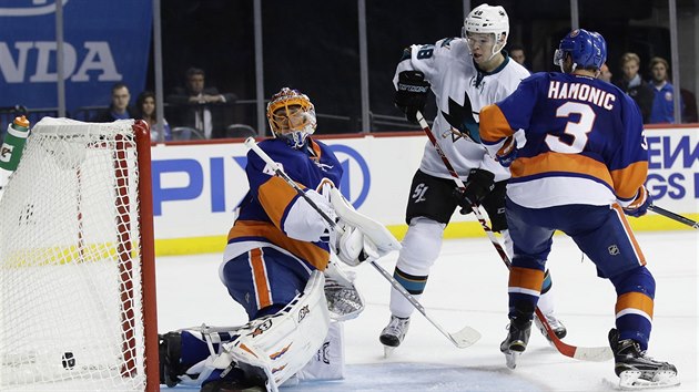 Jaroslav Halk z NY Islanders inkasuje, Tom Hertl ze San Jose to sleduje.