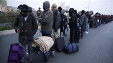 Migranti v uprchlickém táboe v Calais ekají na evakuaci do jiných ubytovacích...