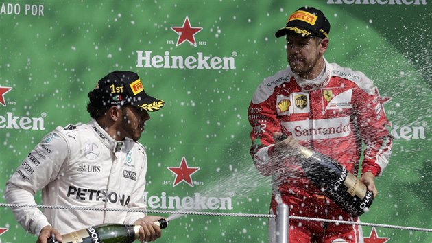 Podiov oslavy mezi vtznm Lewisem Hamiltonem (vlevo) a tetm Sebastianem Vettelem.