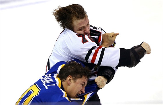Artmij Panarin se bije se Scottem Upshallem v utkání zámoské NHL mezi St....