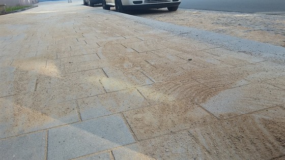 Chodník a vozovka v ulici Sladkovského, kterou písek pokryl vude.