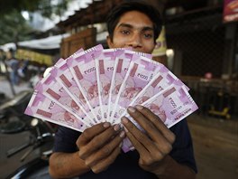 Ind v Ahmadabádu s bankovkami o nominální hodnot 2000 rupií. Indové v jeden...