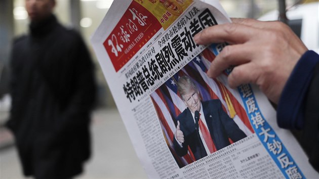 Obyvatel Pekingu studuje mstn noviny s titulkem Zvolen Trumpa prezidentem okovalo Ameriku (9. listopadu 2016)