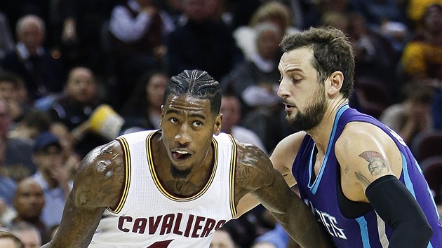 Iman Shumpert (s mem) z Clevelandu se prohnal pes Marca Belinelliho z Charlotte.