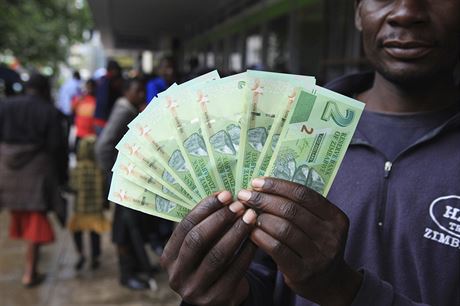 Mu pózuje s novými bankovkami ped bankou v Harare (28. listopadu 2016)