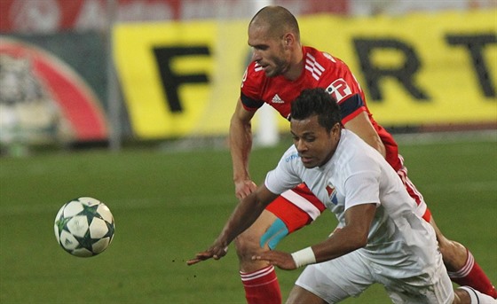 Ostravský fotbalista Carlos Azevedo (v bílém) padá v souboji s olomouckým...