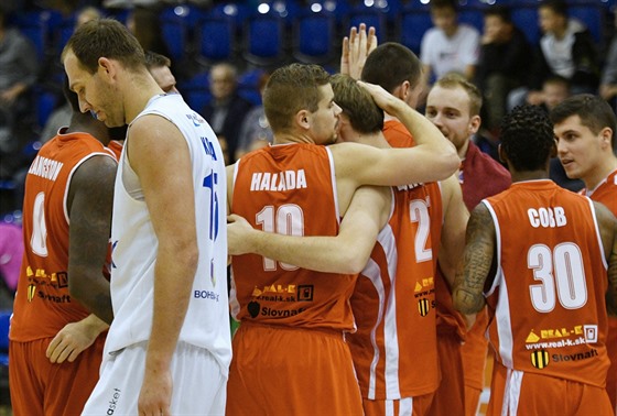 Basketbalisté Komárna s Filipem Haladou v sestav slaví výhru v Dín, v bílém...