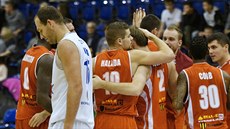 Basketbalisté Komárna s Filipem Haladou v sestav slaví výhru v Dín, v bílém...