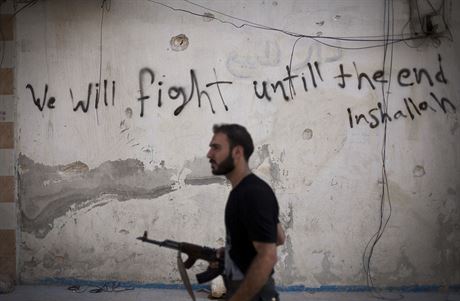 Povstaleck bojovnk prochz ulicemi Aleppa (10. z 2012)