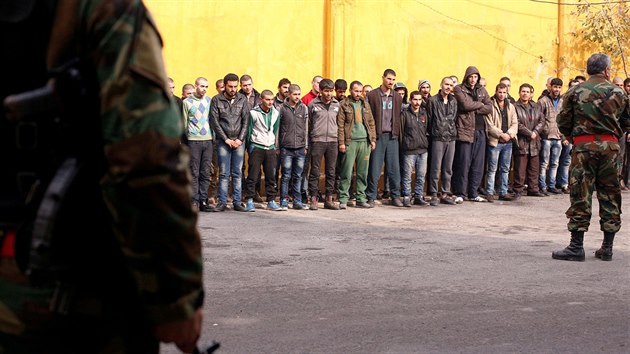 Syrt vojci stoj st u lid, kte se chtj opustit Aleppo (15. prosince 2016).
