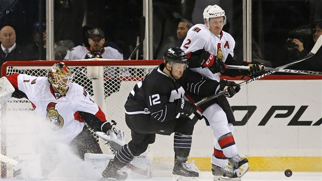 Ottawsk glman Mike Condon sleduje, jak dopadne souboj jeho spoluhre Diona Phaneufa s Joshem Baileym z New York Islanders.