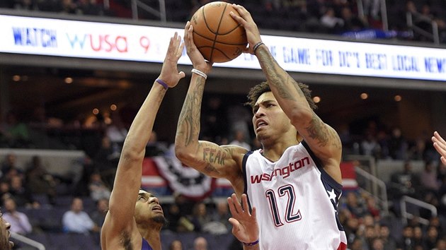 Kelly Oubre Jr. (12) z Washingtonu stl pes Jeremyho Lamba z Charlotte.