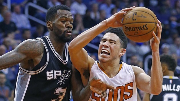 Devin Booker (vpravo) z Phoenixu jde do souboje s Dewaynem Dedmonem ze San Antonia.