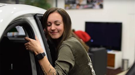 Youtuberka Carrie Kirsten objímá vz BMW. 