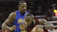 LeBron James (vpravo) z Clevelandu se tlaí kolem Kevina Duranta z Golden State.