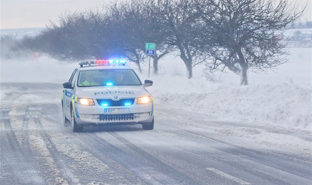 Policie dohlíí na provoz na zasnených silnicích.