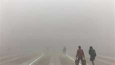 Lidé v ínském eng-ou míí skrz hustý smog na nádraí. (9.ledna 2017)