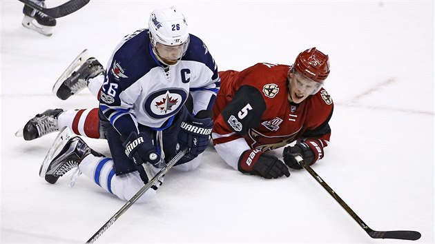 Po puku se natahuj wing Blake Wheeler (vlevo) z Winnipegu a Connor Murphy z Arizony.