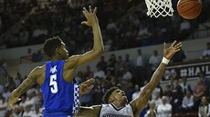 Lamar Peters (v bílém) z Mississippi State zakonuje, brání ho Malik Monk z...