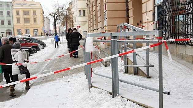 Před Českou spořitelnou na jihlavském Masarykově náměstí je chodník ohraničen páskou. Chodci musí projít po kluzkém úzkém obrubníku.