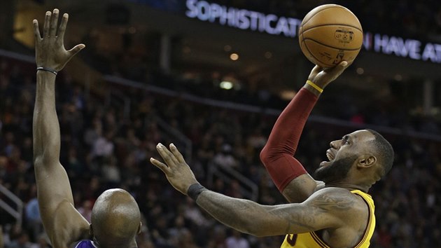 LeBron James (vpravo) z Clevelandu zakonuje na ko Sacramenta pes Anthonyho Tollivera.