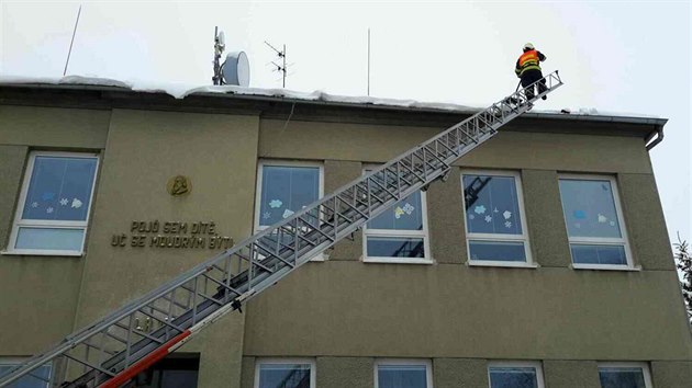 Hasii odklzej ze stechy kolky v Ludov snh a led, aby nehrozil jejich pd.