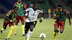 Afriyie Acquah z Ghany prohání obranu Kamerunu. Vpravo je Benjamin Moukandjo,...